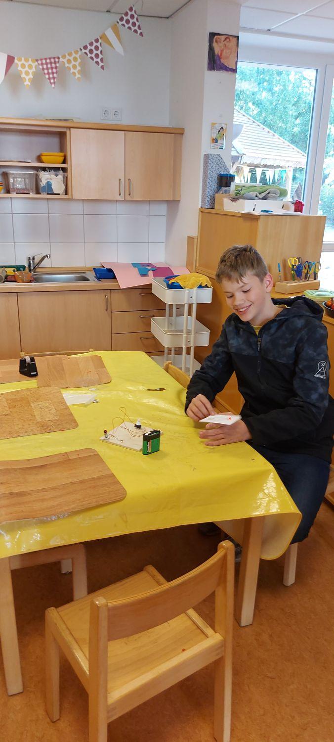 Schüler sitzt an einem Tisch in einer Kindergartengruppe.